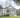 An exterior photo of the Florida State Capitol building taken from the side and angled slightly up. The building is white with red and white striped awnings and large columns.